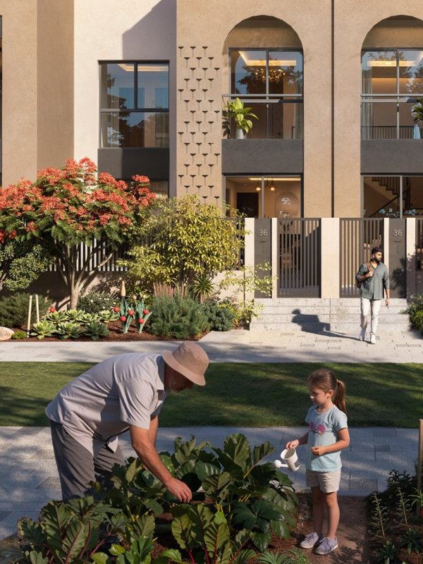 A grandfather and granddaughter tending vegetables outside their townhouse