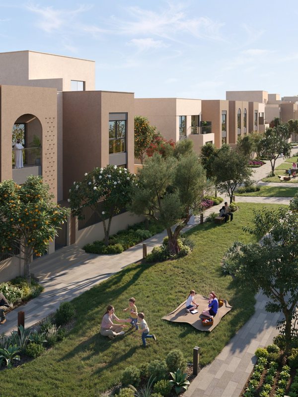 A family picnic on the green lane between townhouses